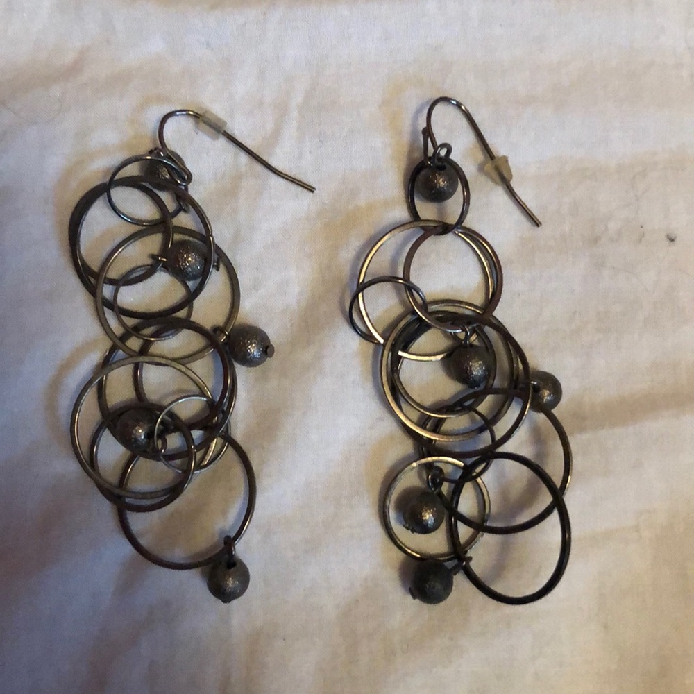 Gray dangly circular earrings.